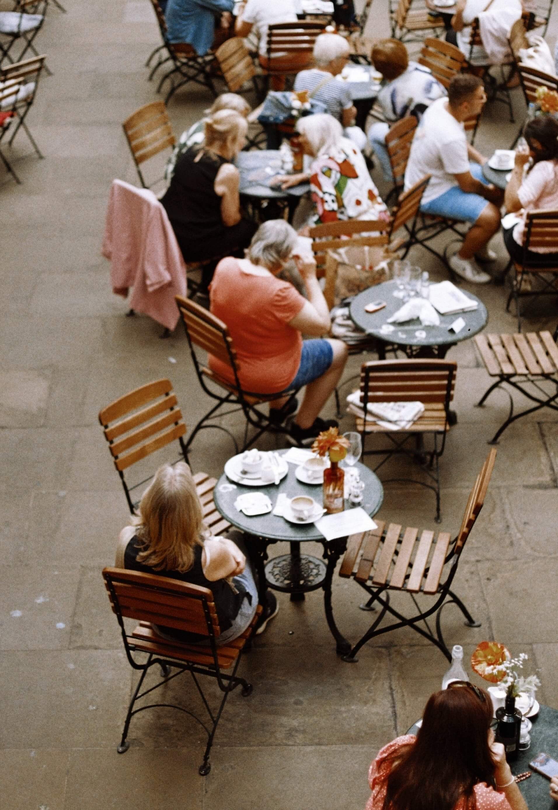 Photo of people enjoying breakfast and coffe from an outdoor cafe